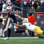 New England Patriots quarterback Drake Maye (10) breaks a tackle by Los Angeles Chargers linebacker Tuli Tuipulotu (45) during the first quarter at Gillette Stadium.