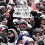 A Patriots fan holds a sign that reads "The Good Old Days Are Back!"
