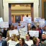 Demonstrators spoke out against threatened cuts to child-care programs at the Minnesota State Capitol in St. Paul on Wednesday