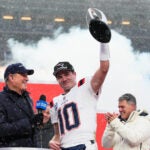 New England Patriots quarterback Drake Maye celebrates with the trophy after the AFC Championship NFL football game between the Denver Broncos and the New England Patriots, Sunday, Jan. 25, 2026, in Denver.