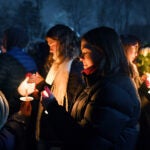 People hold candles during a vigil in Providence, R.I.