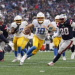 Los Angeles Chargers quarterback Justin Herbert (10) rushes against the New England Patriots during the fourth quarter at Gillette Stadium.