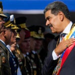 Venezuela's President Nicolas Maduro places his hand over his heart while talking to high-ranking officers during a military ceremony on his inauguration day for a third term, in Caracas, Venezuela.