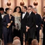 Sara Murphy, foreground left, appearing with writer-director Paul Thomas Anderson, foreground right, and other cast members, as well as presenter Julia Roberts, right, as they accept the award for best motion picture - musical or comedy for "One Battle After Another" during the 83rd Golden Globes on Sunday, Jan. 11, 2026, at the Beverly Hilton in Beverly Hills, Calif.