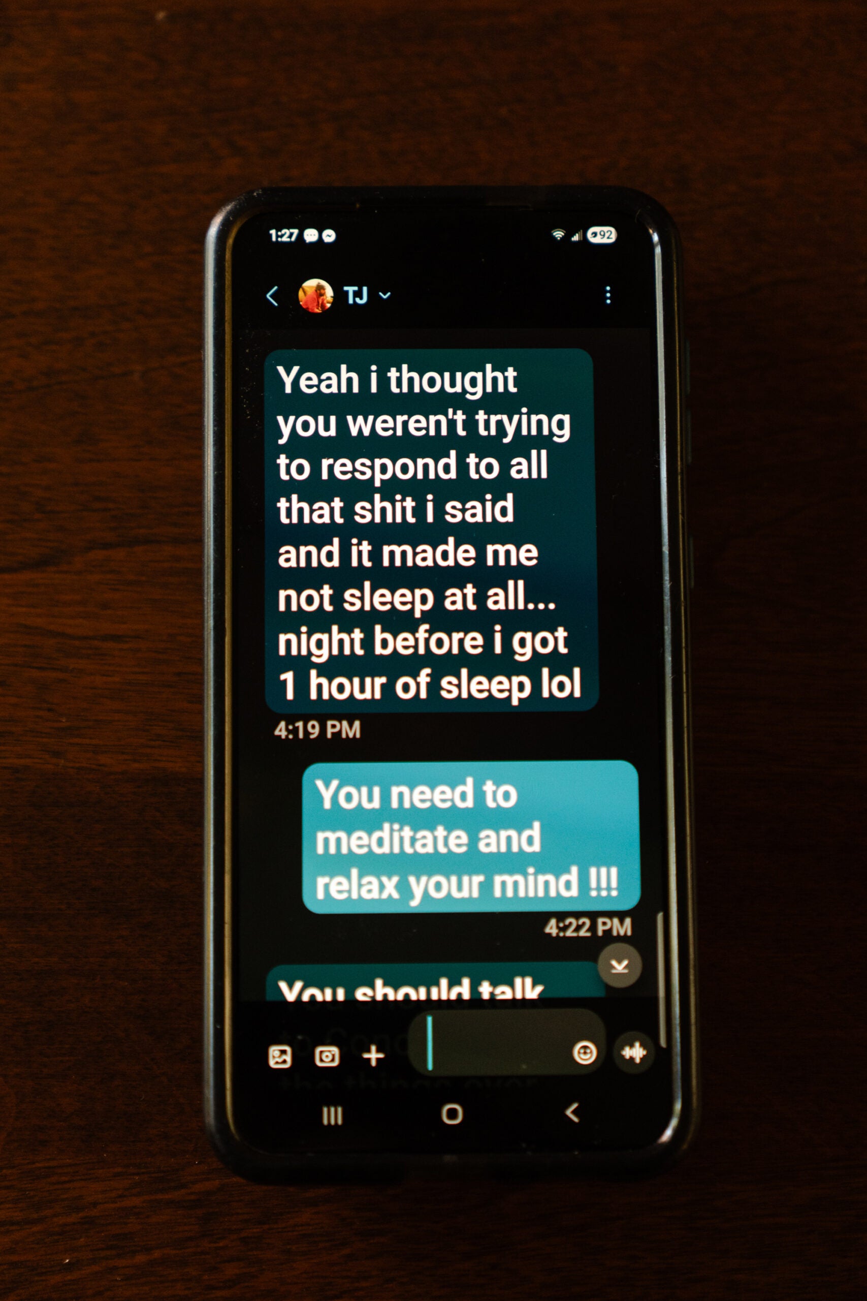 A text message exchange between Angela Kimball and her son, TJ Kimball, is displayed on her smartphone. 