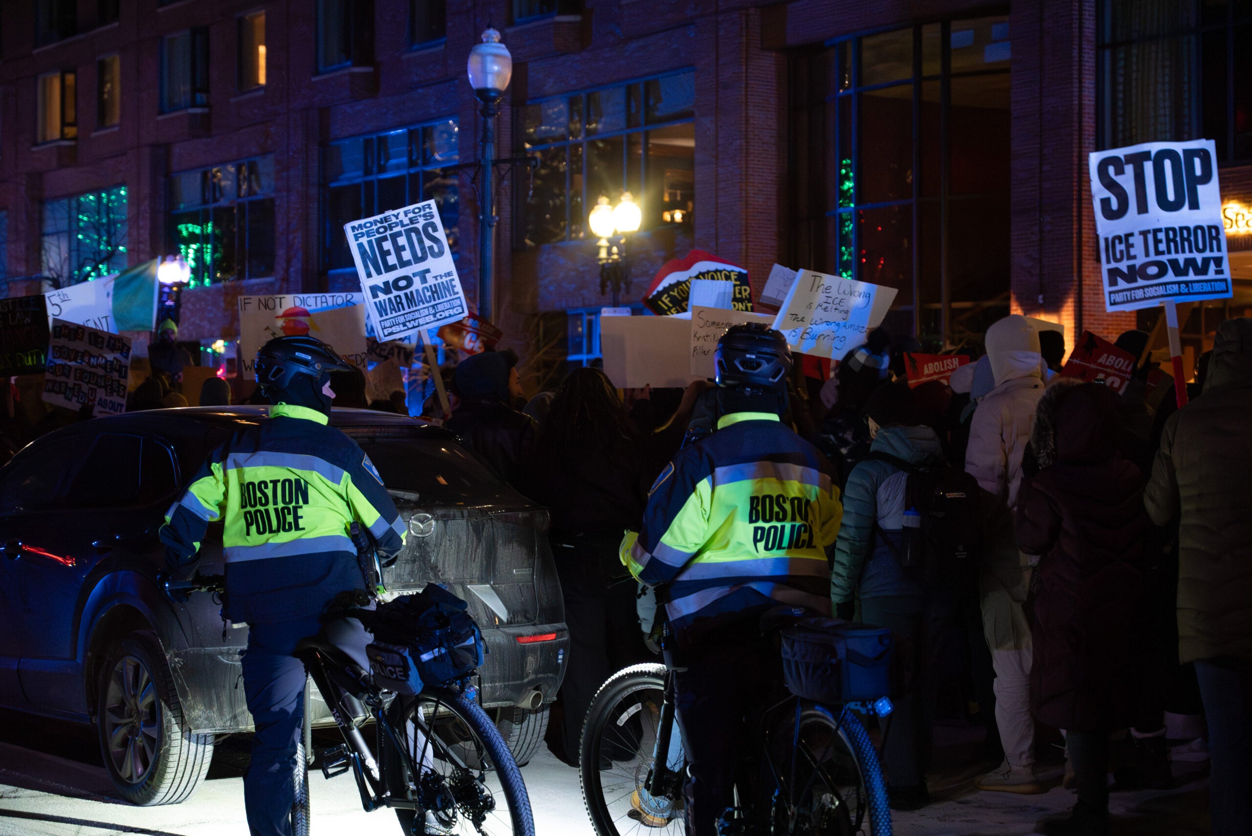 Boston police officers look on as protesters march toward Boston Common.