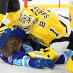 Boston Bruins goaltender Jeremy Swayman (1) takes down Tampa Bay Lightning left wing Brandon Hagel (38) during the second period of a Stadium Series NHL hockey game Sunday, Feb. 1, 2026, in Tampa, Fla.