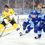 Boston Bruins defenseman Charlie McAvoy (73) moves the puck away from Tampa Bay Lightning left wing Brandon Hagel (38) during the first period of a Stadium Series NHL hockey game Sunday, Feb. 1, 2026, in Tampa, Fla.