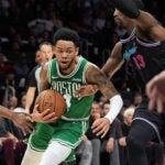 Boston Celtics guard Anfernee Simons (4) comes under pressure from Miami Heat center Bam Adebayo (13) during the first half of an NBA basketball game, Thursday, Jan. 15, 2026, in Miami.