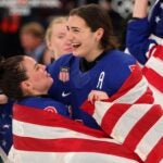 Cayla Barnes #3 and Megan Keller #5 of Team United States celebrate winning the gold medals after the team's 2-1 overtime victory in the Women's Gold Medal match between the United States and Canada on day 13 of the Milano Cortina 2026 Winter Olympic games at Milano Santagiulia Ice Hockey Arena on February 19, 2026 in Milan, Italy.