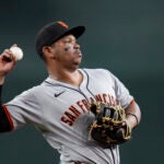 San Francisco Giants first baseman Rafael Devers tosses a ball into the crowd during the sixth inning of a baseball game against the Arizona Diamondbacks Wednesday, Sept. 17, 2025, in Phoenix.