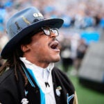 Former Carolina Panthers player Cam Newton reacts on the field before an NFL divisional playoff football game between the Los Angeles Rams and the Carolina Panthers, Saturday, Jan. 10, 2026, in Charlotte, N.C.