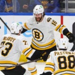 Boston Bruins center Pavel Zacha (18) celebrates his game winning goal with defenseman Charlie McAvoy (73) and right wing David Pastrnak (88) following the overtime period of an NHL hockey game against the Buffalo Sabres Wednesday, March 25, 2026, in Buffalo, N.Y.