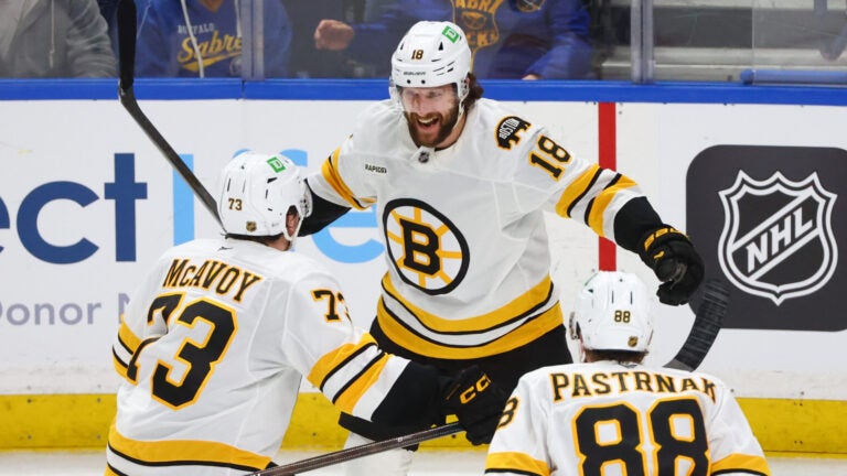 Boston Bruins center Pavel Zacha (18) celebrates his game winning goal with defenseman Charlie McAvoy (73) and right wing David Pastrnak (88) following the overtime period of an NHL hockey game against the Buffalo Sabres Wednesday, March 25, 2026, in Buffalo, N.Y.