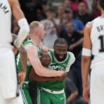 Boston Celtics guard Jaylen Brown (7) is restrained as he argues a call during the first half of an NBA basketball game against the San Antonio Spurs in San Antonio, Tuesday, March 10, 2026