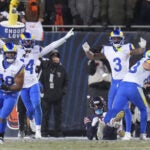 Los Angeles Rams linebacker Jesse Luketa (40) holds the football after he and teammates _ Cobie Durant (14), Kam Curl (3) and Nate Landman _ forced an incomplete pass intended for Chicago Bears wide receiver Luther Burden III, bottom right, on a fourth down play during the second half of an NFL football divisional playoff game Sunday, Jan. 18, 2026, in Chicago.