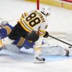 Boston Bruins right wing David Pastrnak (88) puts the puck past Buffalo Sabres goaltender Alex Lyon (34) during the overtime period in Game 5 of a first-round NHL hockey Stanley Cup playoff series Tuesday, April 28, 2026, in Buffalo, N.Y.