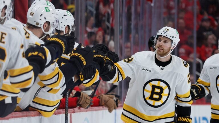 Boston Bruins center Elias Lindholm (28) celebrates with teammates after scoring against the Detroit Red Wings during the third period of an NHL hockey game Saturday, March 21, 2026, in Detroit.