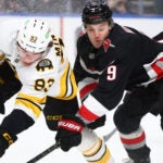Boston Bruins center Fraser Minten (93) and Buffalo Sabres center Josh Norris (9) collide during the first period of an NHL hockey game Saturday, Dec. 27, 2025, in Buffalo, N.Y.