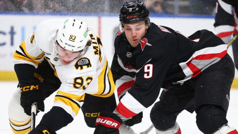 Boston Bruins center Fraser Minten (93) and Buffalo Sabres center Josh Norris (9) collide during the first period of an NHL hockey game Saturday, Dec. 27, 2025, in Buffalo, N.Y.