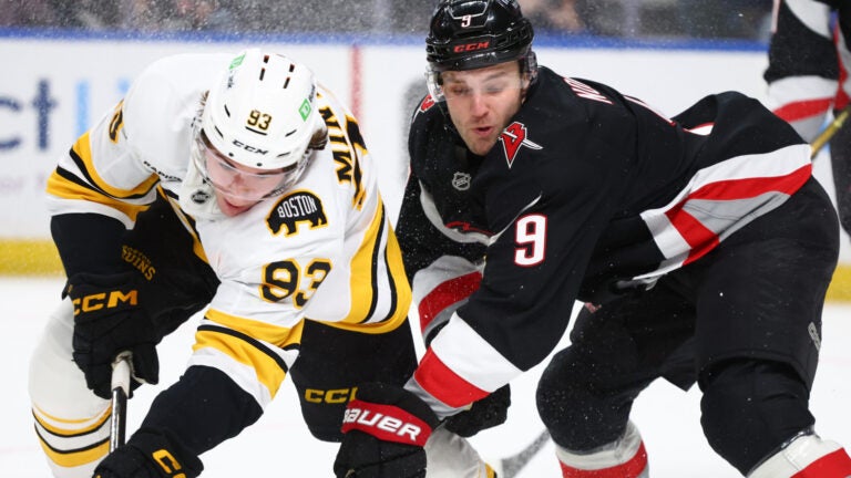 Boston Bruins center Fraser Minten (93) and Buffalo Sabres center Josh Norris (9) collide during the first period of an NHL hockey game Saturday, Dec. 27, 2025, in Buffalo, N.Y.