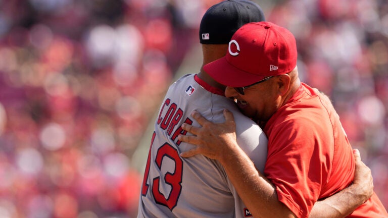 Boston Red Sox manager Alex Cora, left, Cincinnati Reds manager Terry Francona, right, embrace before an opening-day baseball game in Cincinnati, Thursday, March 26, 2026.