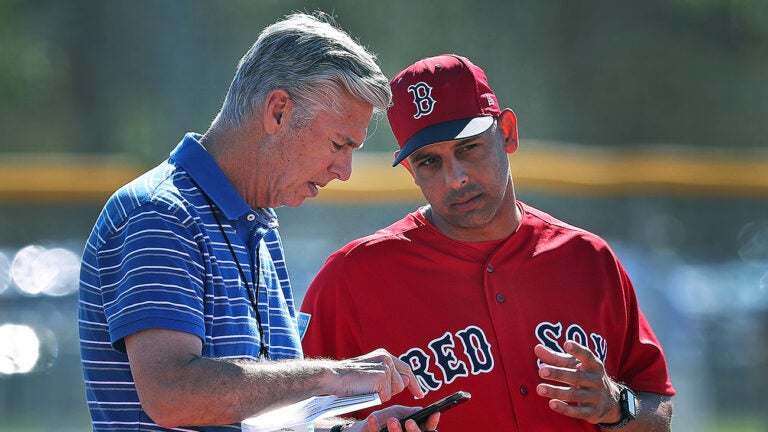 Red Sox president of baseball operations Dave Dombrowski (left) makes a phone call while he was talking to manager Alex Cora (right) in the infield as pitchers did drills on the mound. Spring Training for the Red Sox continued today at the Player Development Complex at Jet Blue Park.