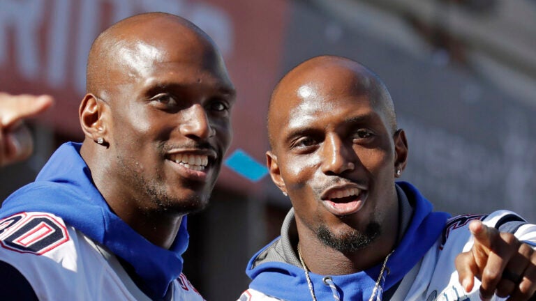 In this Feb. 5, 2019, file photo, New England Patriots Jason, left, and Devin McCourty react to fans during their Super Bowl victory parade in Boston. The Patriots’ twin combination in the secondary will remain intact for another season. A person familiar with the move says cornerback Jason McCourty has agreed to a two-year deal to remain with the Super Bowl champions. The person spoke on the condition of anonymity to The Associated Press because teams are not permitted to announce any moves until later in the day.