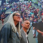 Denise and Bill Richard walk past a mural photo of Boston Marathon runners hanging on a building on Boylston Street.