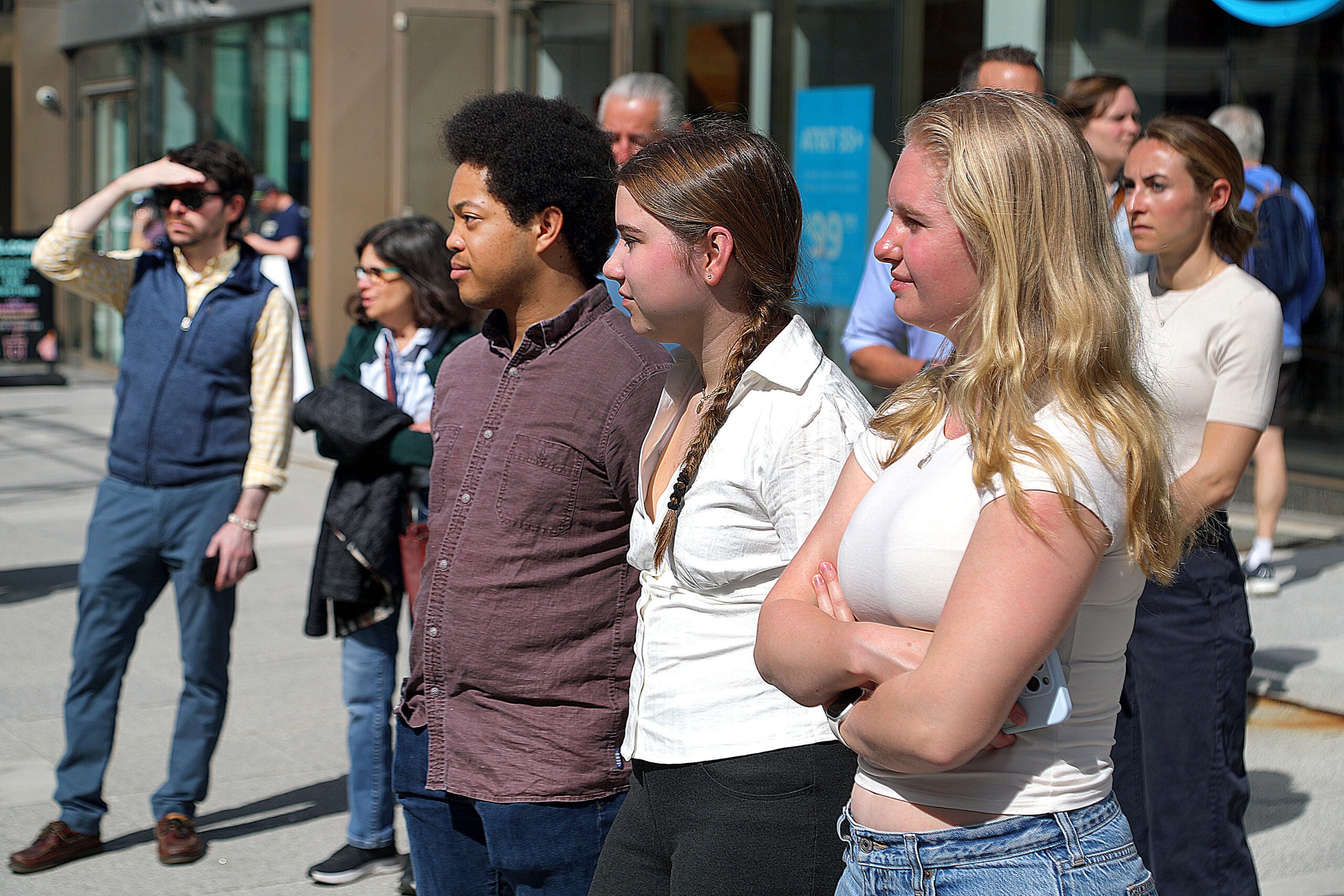 Spectators pause on the sidewalk of Boylston Street to pay respects to survivors and families who lost loved ones at the 2013 Boston Marathon bombings.