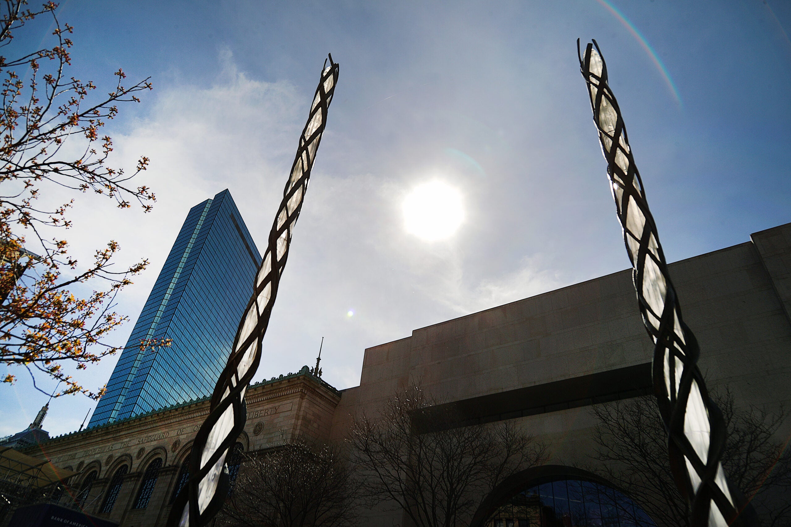 Two of four memorial glass columns marking the site of the first Boston Marathon bombing glisten in the sun near the finish line on Boylston Street.