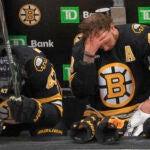 Boston Bruins center Mark Kastelic (47) and right wing David Pastrnak (88) on their bench down 6-0 after a fight against the Buffalo Sabres during third period NHL action of game four in the first round of playoffs at TD Garden on Sunday April 26, 2026.