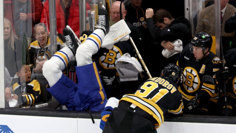 Bruins defenseman Nikita Zadorov, right, sends Sabres defensemanOwen Power into the bench during the first period against the Sabres on Saturday, October 11, 2025.