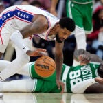 Philadelphia 76ers' Paul George, left, chases a loose ball past the Boston Celtics' Neemias Queta