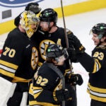 Boston Bruins goaltender Joonas Korpisalo (70) with centers Elias Lindholm (28), Marat Khusnutdinov (92) and Fraser Minten (93) celebrate after their team's win over the Pittsburgh Penguins in an NHL hockey game Sunday, Jan. 11, 2026, in Boston.