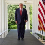 President Donald Trump walks through the Colonnade of the White House.