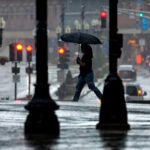 A pedestrian uses an umbrella to protect herself from rain in downtown Boston.