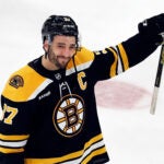 Boston Bruins' Patrice Bergeron raises his stick to the fans after losing to the Florida Panthers in overtime during Game 7 of an NHL hockey Stanley Cup first-round playoff series, April 30, 2023, in Boston.