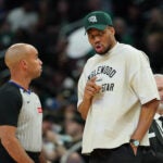 Injured Milwaukee Bucks' Giannis Antetokounmpo, center right, talks with an official, center left, during the first half of an NBA basketball game against the Boston Celtics, Friday, April 3, 2026, in Milwaukee.