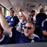 Members of the Tartan Army sing and cheer during a school bus ride to Foxborough for Scotland’s World Cup match.