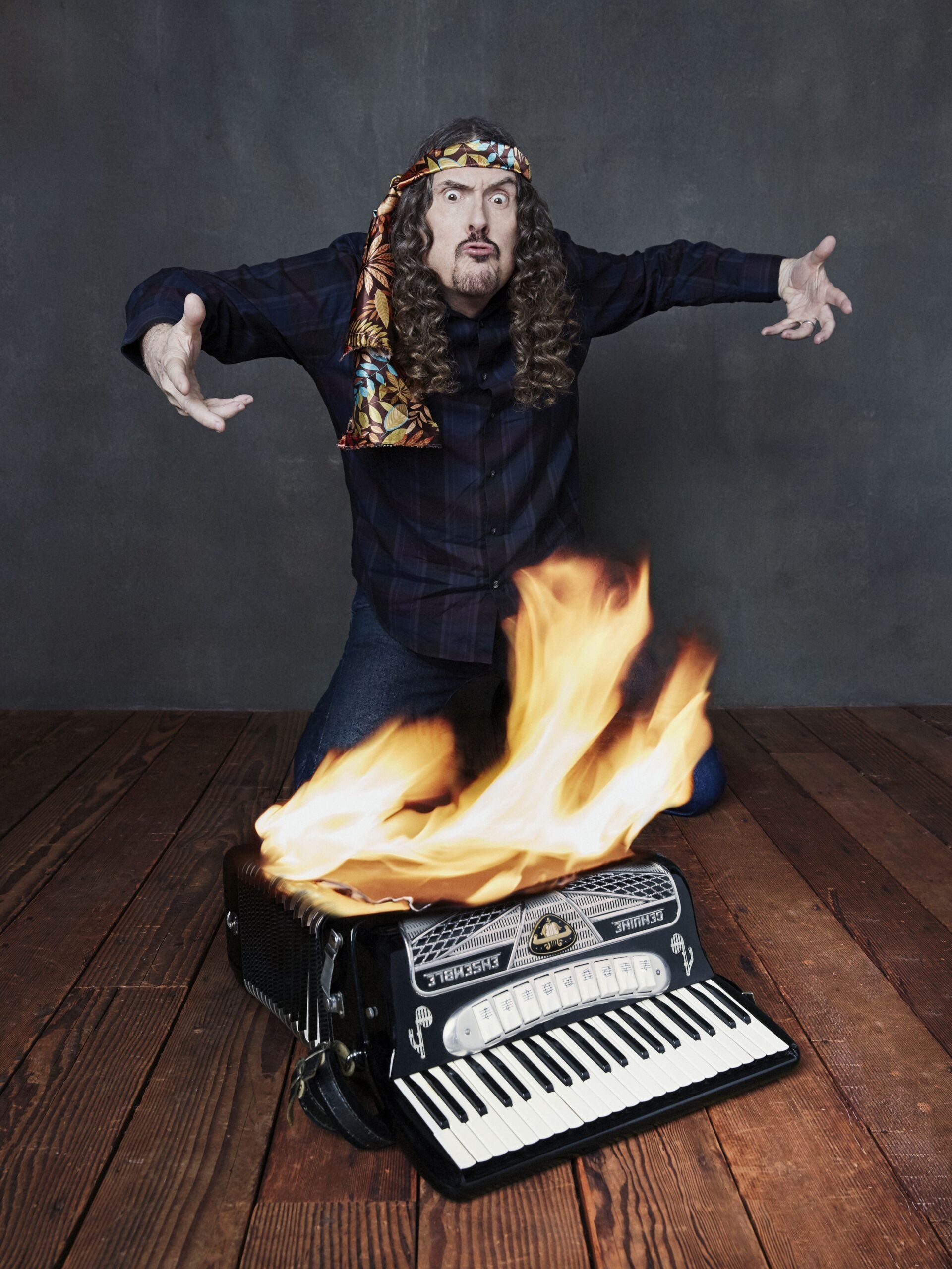 A weird man with a burning accordian.