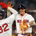 Boston Red Sox left fielder Jarren Duran (right) high-fives shortstop Andruw Monasterio (32) after Duran scores against the Chicago White Sox during the seventh inning at Fenway Park on Aug. 5, 2026, in Boston.