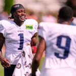 New England Patriots wide receiver A.J. Brown (1) talks with teammates while stretching during the team's NFL football training camp, Friday, July 31, 2026, in Foxborough, Mass.