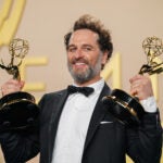 Matthew Rhys poses with two Emmy Awards.