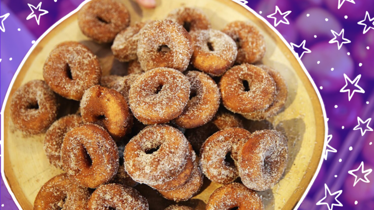A plate of apple cider doughnuts against a purple background with star graphics