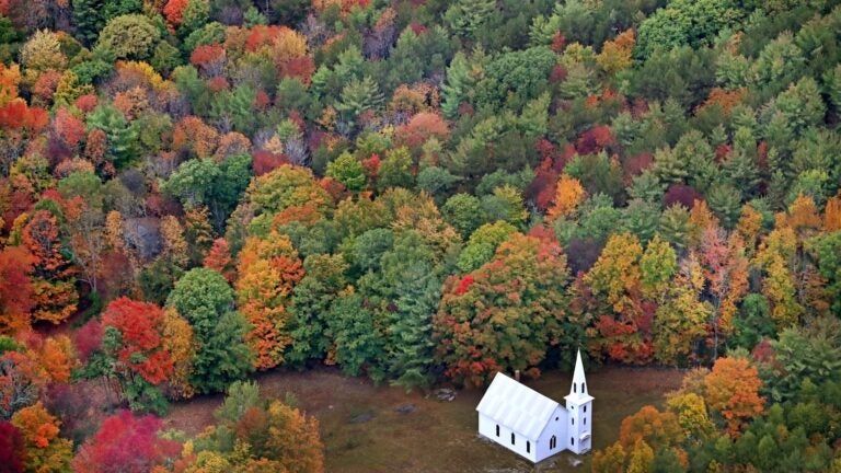 Fall foliage surrounds a small church near East Parsonsfield, Maine.